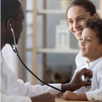Paediatric-Services Doctor with a stethoscope examining a young boy